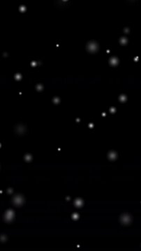 黒背景にふわふわと降り注ぐ白い光の玉とボケエフェクト（縦型・動画素材・幻想的）
