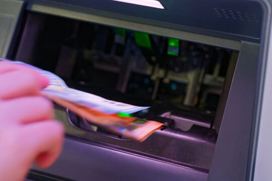 Person withdrawing cash from an automated teller machine ATM