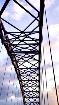 Low angle shot of a steel truss bridge structure against the sky