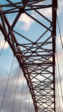 Low angle shot of a steel truss bridge structure against the sky
