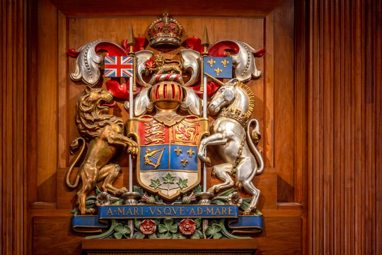 Ottawa, Ontario, Canada. July 18, 2026. Detailed close-up of the carved wooden coat of arms of Canada mounted on a wood-paneled wall.