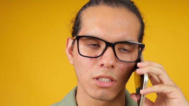 Young adult man talking on smartphone expressing emotions