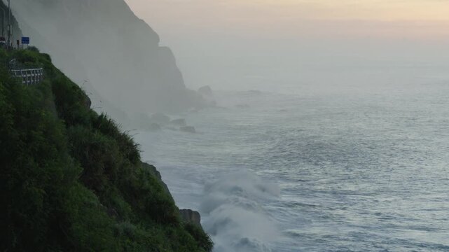 cliffs and ocean wave in golden sunrise light.