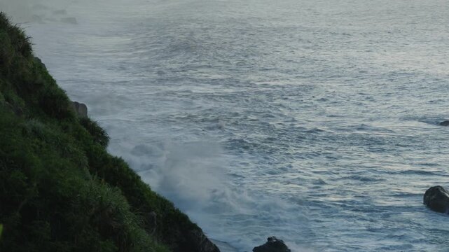 cliffs and ocean wave in golden sunrise light.