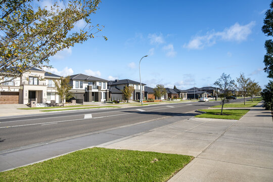 a clean, modern street&nbsp;in a residential estate within Tarneit, Melbourne Australia. A row of contemporary double-storey homes&nbsp;lined along a broad asphalt road&nbsp;in an outer suburb.