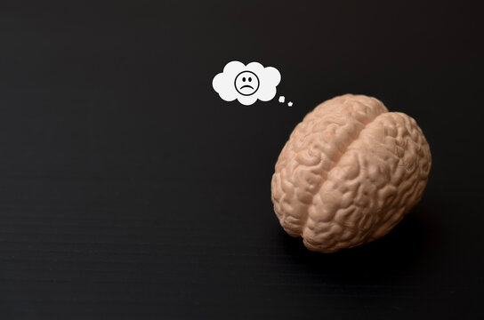 Depression and Anxiety Psychological Concept Featuring Brain Model and Frowny Face Emoticon