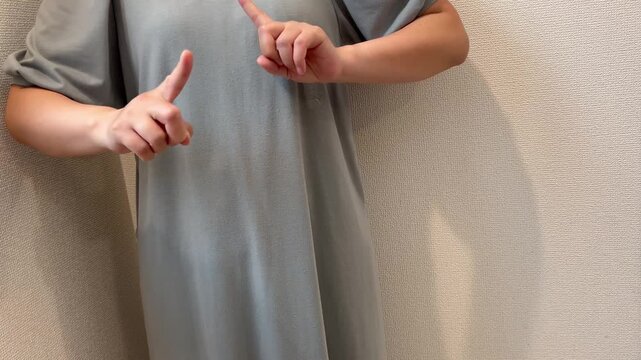 バツマークのジェスチャーをする女性