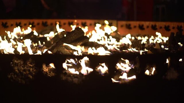 Warm fire pit with logs and flames burning at night