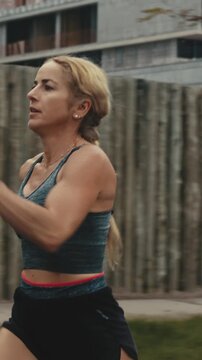 Close up of female runner's face and torso against a wooden fence