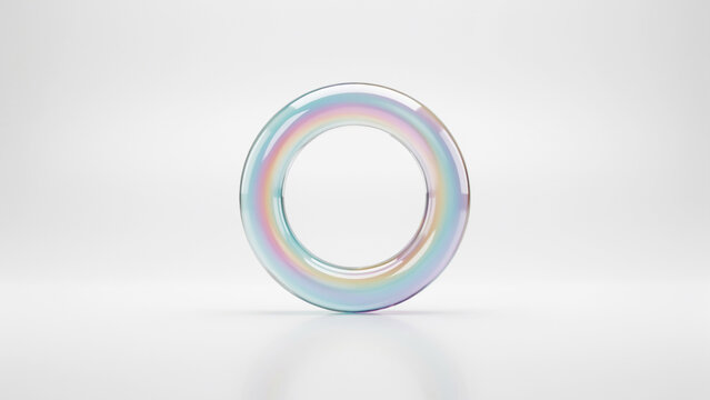 Iridescent transparent torus shape suspended in air against a bright white studio background