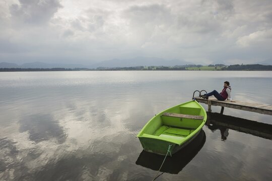 Woman, wooden jetty, green rowing boat, Hopfensee, Hopfen am See, near F&uuml;ssen, Ostallg&auml;u, Allg&auml;u, Bavaria, Germany