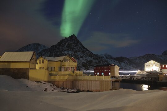 Night scene of a snow-covered village with auroras in the sky and mountains in the background, winter, winter, Nyksund, Langoya, Vesteralen, Nordland, Norway