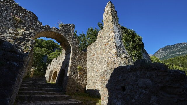 Historic archway and remains of walls against a wooded background, Mystras, Mistra, UNESCO World Heritage Site, Medieval Byzantine ruined city, north-west of Sparta, foothills of the Tyagetos Mountains, Peloponnese, peninsula, Greece