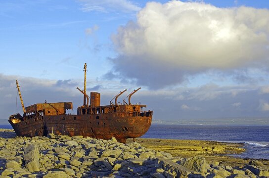 Rusty shipwreck on rocky coast with big sky, Arran Islands, Ireland