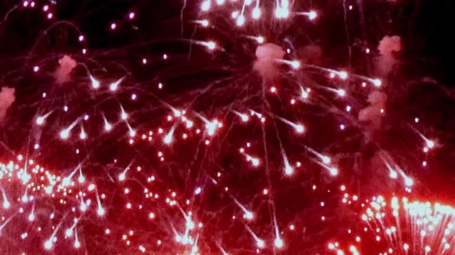 A mesmerizing display of fireworks bursts into brilliant patterns across the dark sky, creating a celebratory atmosphere on July Fourth. Sparks cascade and shimmer.