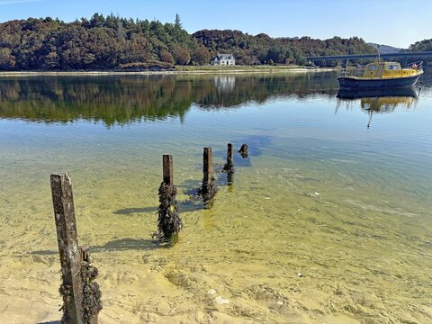 Shoreline landscape with clear water and a yellow boat, calm atmosphere, Silver Sands of Morar, Morar, Scotland, United Kingdom