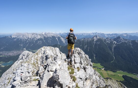 Mountaineer climbing in the rock, climbing to the Upper Wettersteinspitze, at the back summit of the Karwendel Mountains, Wetterstein Mountains, Bavarian Alps, Bavaria, Germany