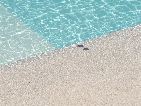 Clear blue swimming pool water and textured deck