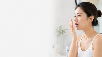Naklejka premium Woman Checking Breath Freshness in Bright Bathroom Mirror Concept