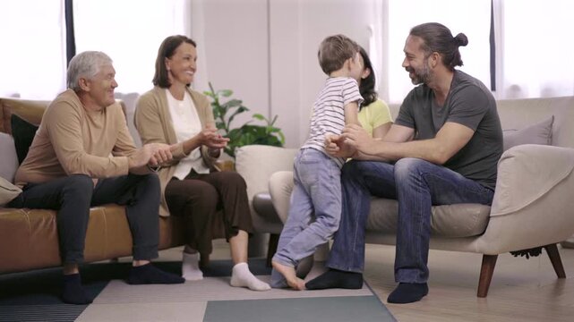 Multi-generation family talking and laughing together at home