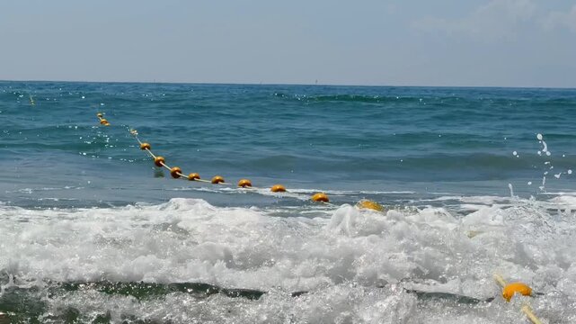 Beach Safety Buoy Rope Line in Breaking Ocean Waves. Rip current no swimming zone concept