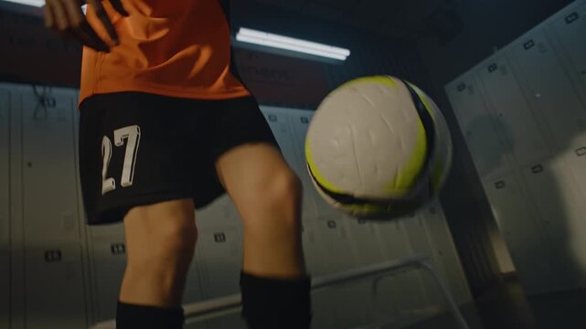 Student Athlete Using Locker Room Space For Extra Individual Practice. Absorbed in Routine, Young Man Works on Agility, Tapping and Dribbling Soccer Ball. Concept of Work Ethic and Passion For Sport.