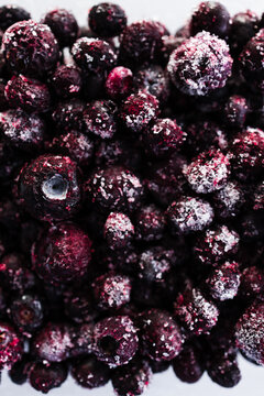 close up of frozen blueberries with ice crystals in glass container