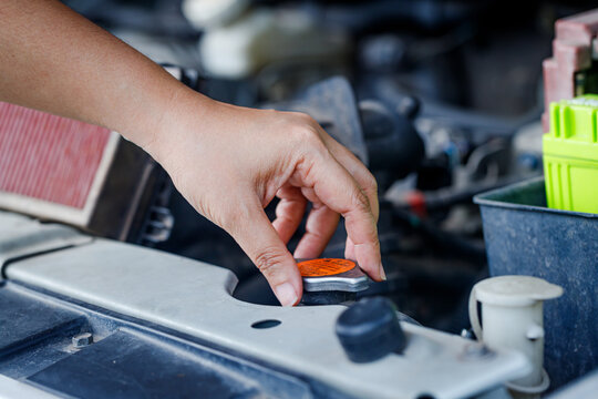Close up of a hand of woman is checking a liquid coolant pot