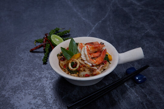 Thai Drunken Noodles with prawn (Pad Kee Mao) on dark background.