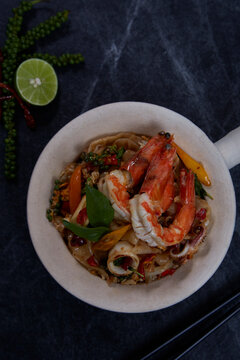 Thai Drunken Noodles with prawn (Pad Kee Mao) on dark background.