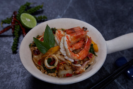 Thai Drunken Noodles with prawn (Pad Kee Mao) on dark background.