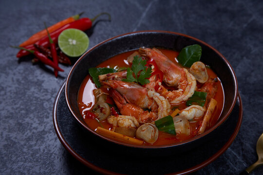 Hot and sour spicy shrimps prawns soup with curry lemon lime galangal red chili straw mushroom, Thai Food Tom Yum Kung.