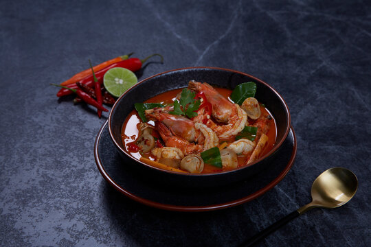 Hot and sour spicy shrimps prawns soup with curry lemon lime galangal red chili straw mushroom, Thai Food Tom Yum Kung.