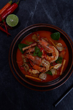 Hot and sour spicy shrimps prawns soup with curry lemon lime galangal red chili straw mushroom, Thai Food Tom Yum Kung.