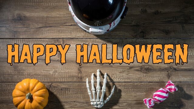 Spooky halloween decorations on wooden background with pumpkin skeleton and candy