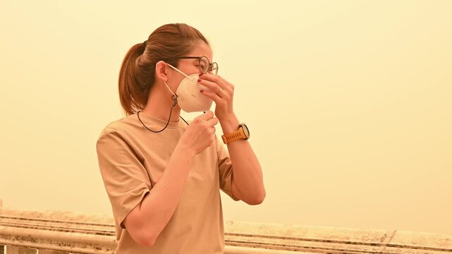 Asian woman wearing face mask for prevent bad air pollution. PM2.5 levels meaning the air quality posed a health hazard.