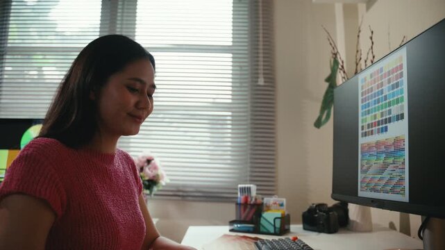 Professional asian woman retouching photos or drawing on a digital tablet with a stylus. A freelance artist working from her home studio