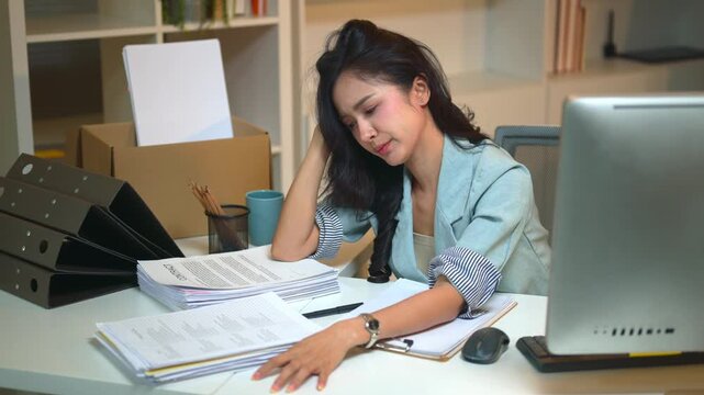 Stressed Businesswoman Covering Face at Office Desk Overwhelmed by Work and Paperwork