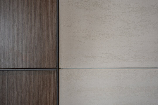 Textured beige plaster and dark wood paneling wall background with a vertical dividing line.