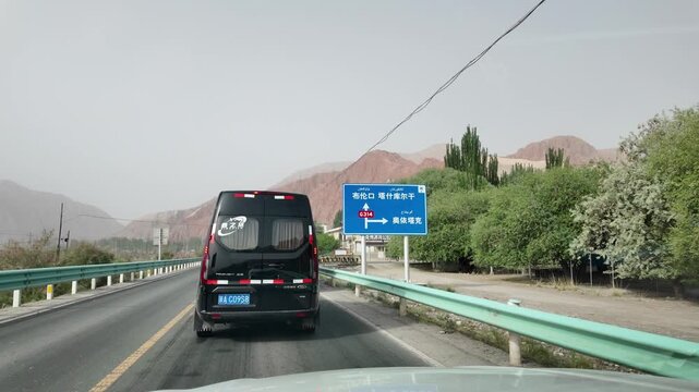 Car view driving through arid canyon with barren mountains along G314 highway near Oytagh Glacier Xinjiang