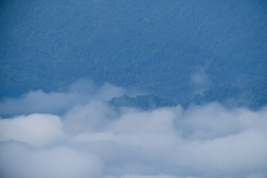 Breathtaking aerial view of misty valleys and lush green tropical rainforest mountains at dawn