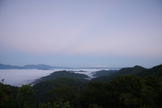 Breathtaking aerial view of misty valleys and lush green tropical rainforest mountains at dawn