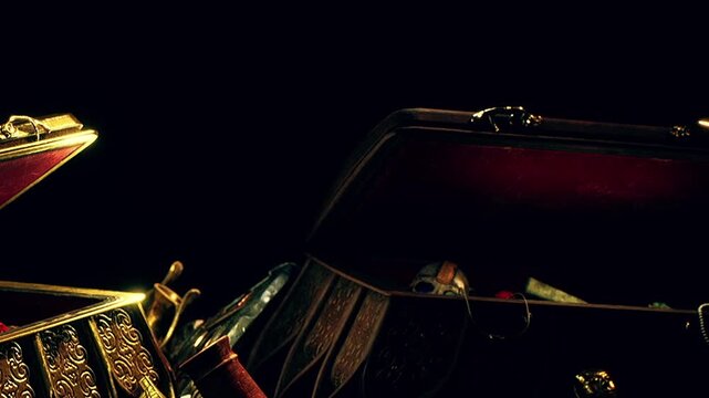 A treasure chest is open, showing different items like jewelry, masks, and other objects. The scene is dark, with light reflecting off the chest. The setting suggests an exploration or discovery.