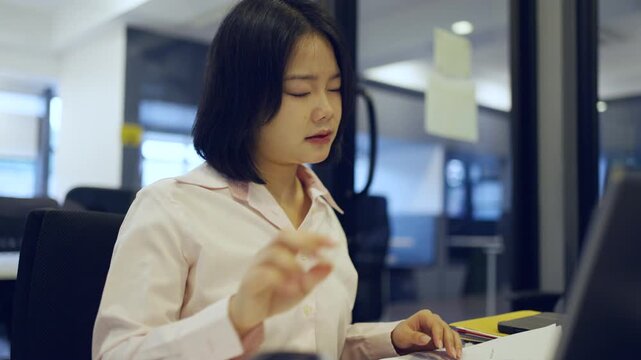 Young Asian woman working at office and have a pain office syndrome