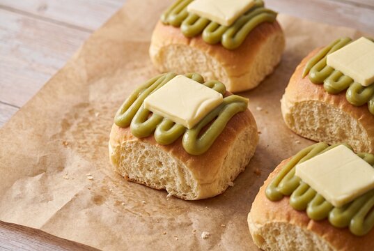Freshly baked soft bread rolls topped with pandan kaya jam and a slice of butter