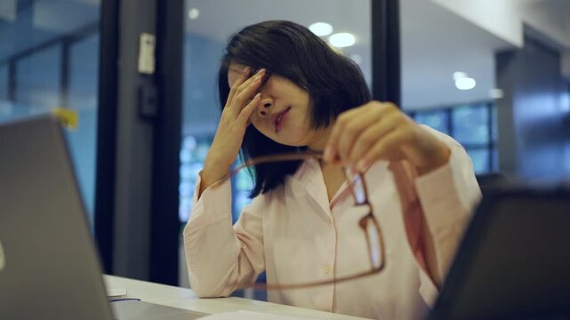 Young Asian woman working at office and have a pain office syndrome and tried after working 