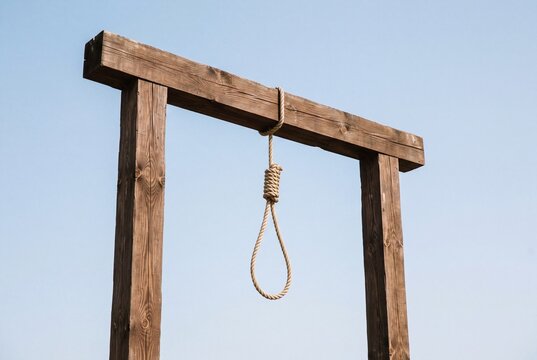Wooden gallows with a hangmans noose against a clear blue sky