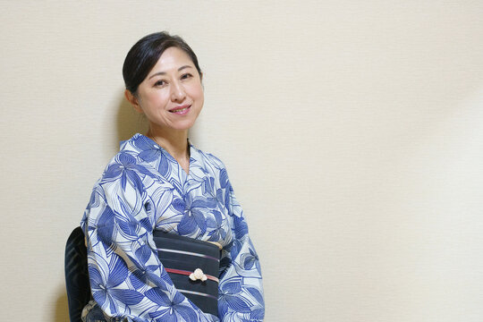 浴衣を着たカメラ目線のシニア女性　黒い帯に帯留