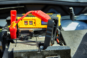 Fototapeta premium Selective focus of charging a car with electricity through cables from a compact battery