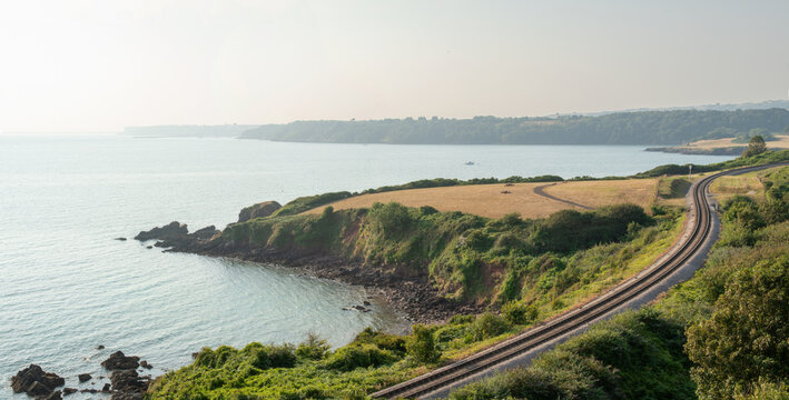 Beautiful Devon coastline with a train track winding across the frame. South Devon and Torbay tourism. Part of the English Riviera. Torquay, Paignton, Brixham. Dartmouth steam railway. 